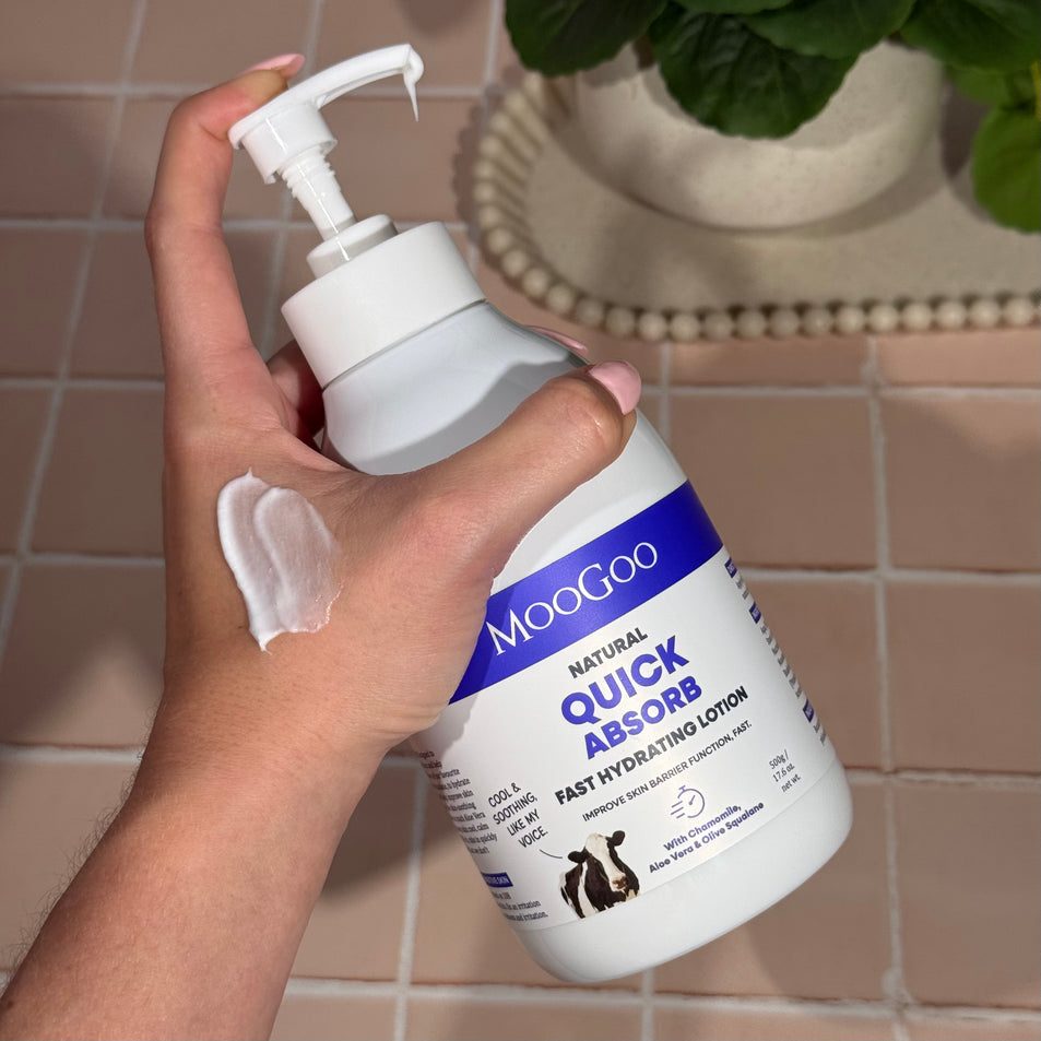 Hand holding MooGoo Quick Absorb Lotion 500g, fast absorbing daily moisturiser with aloe vera and chamomile for delicate and damaged skin.