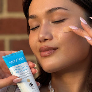 Woman applying MooGoo Natural Tinted SPF 40 Face Cream to her face - smooth complexion, reduce redness, hydrate skin. Perfect under makeup, for all skin tones and Eczema safe SPF.